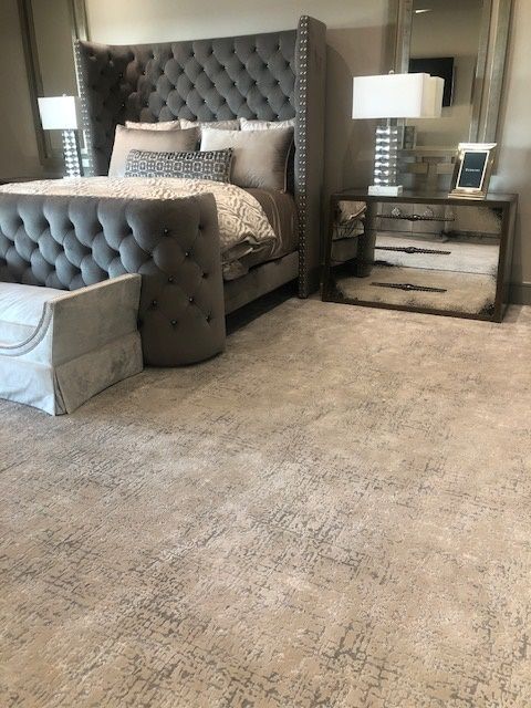 A bedroom with a bed , nightstands , lamps and a mirror.