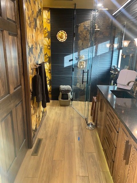 A bathroom with a sink and a walk in shower.