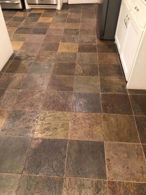 A room with a tiled floor and a wooden cabinet. Menke Inc. Abilene, TX