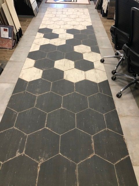 A long hallway with black and white hexagon tiles