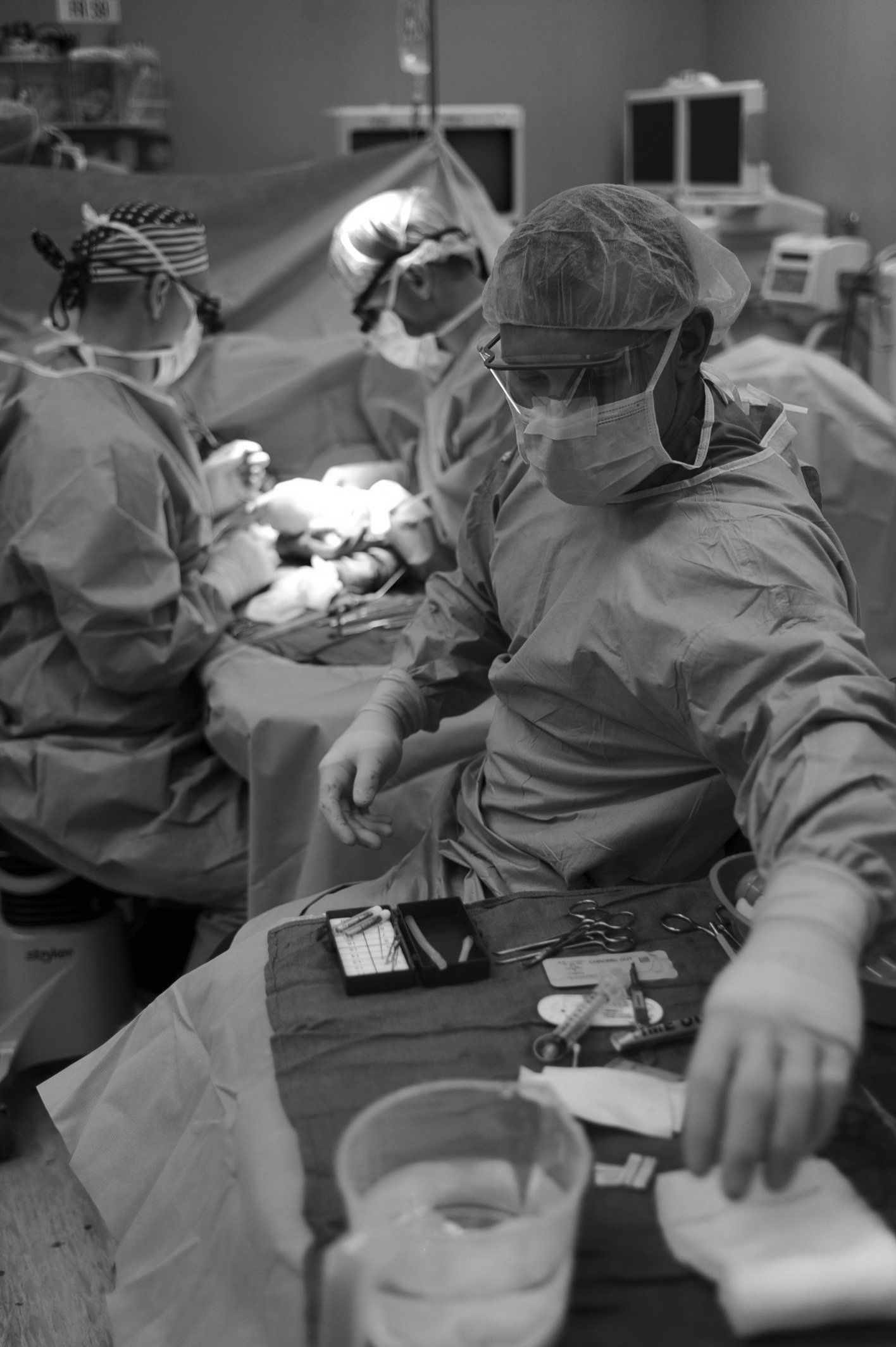 A black and white photo of a surgeon in an operating room