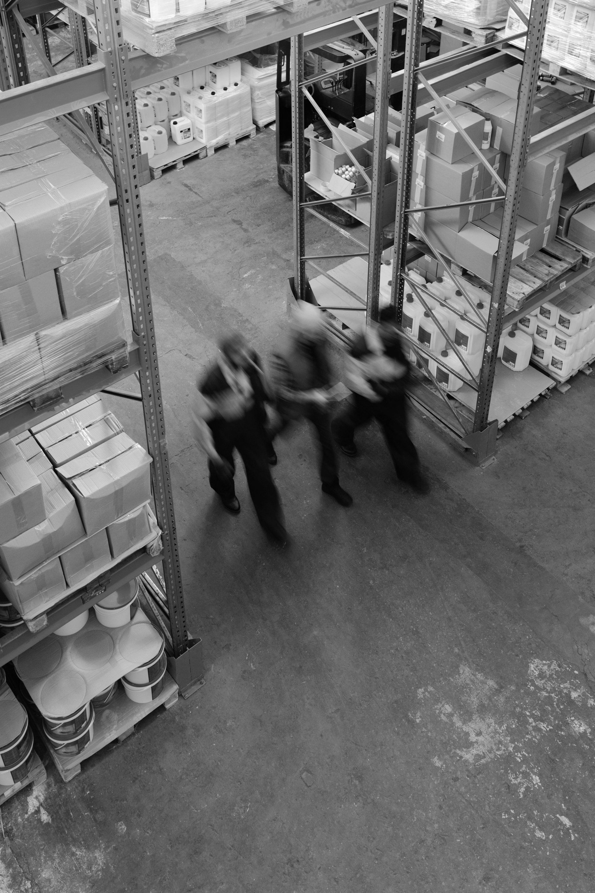 A group of people are standing in a warehouse.