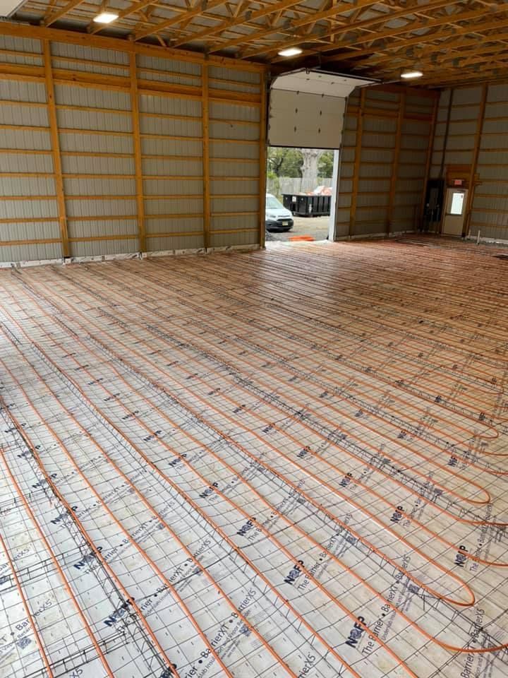 A large warehouse with a lot of pipes on the floor.