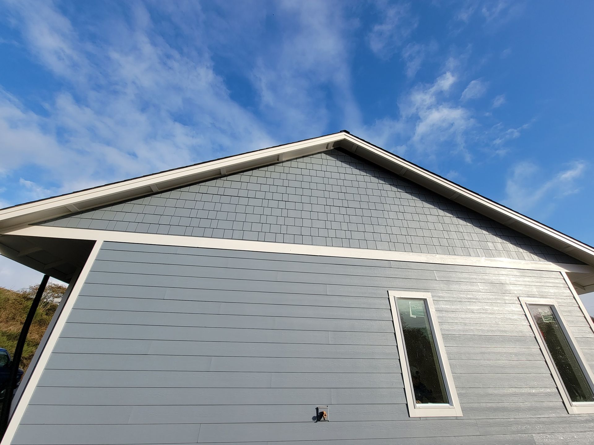 A house with a blue sky and white clouds in the background