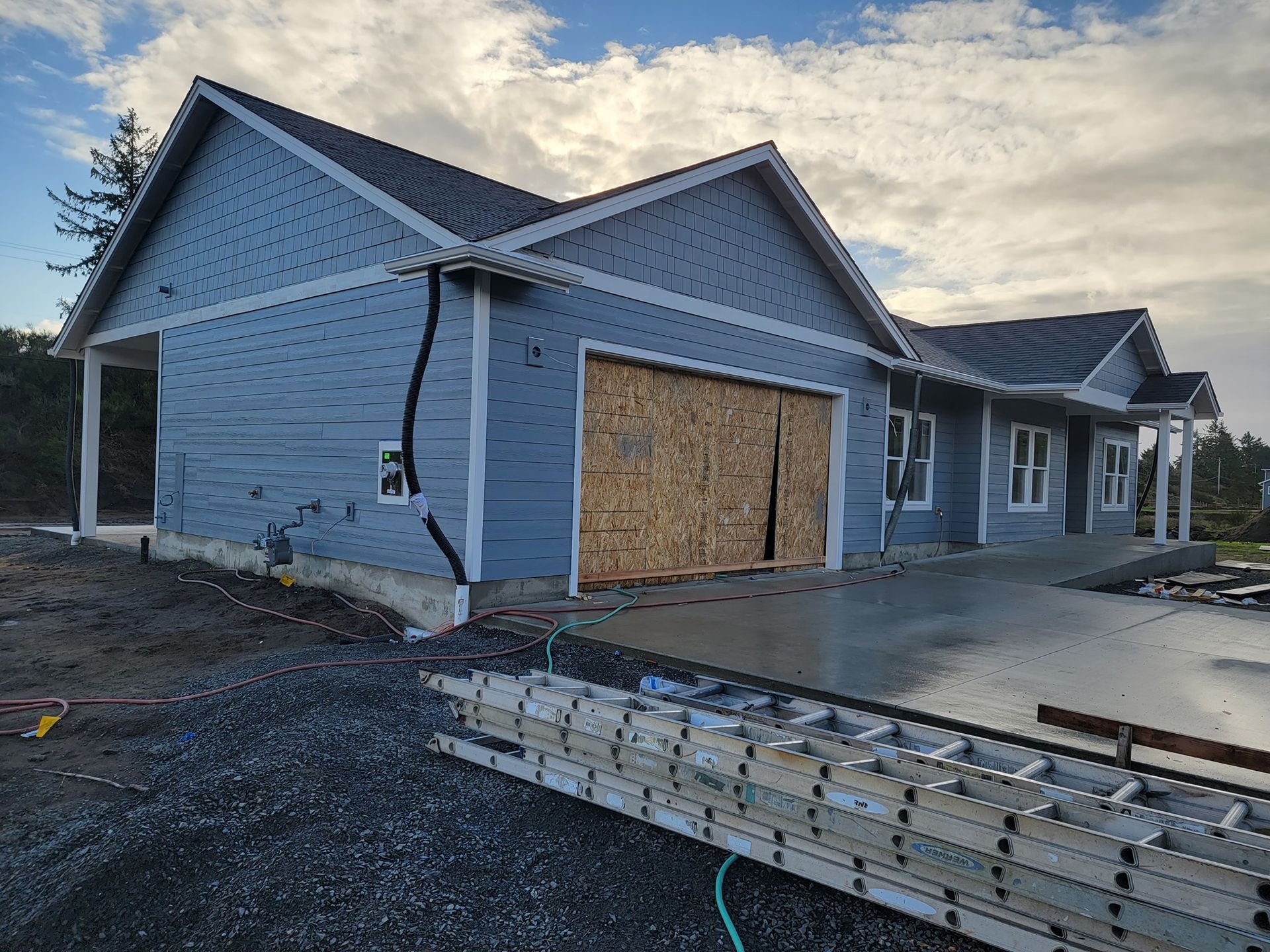A ladder is sitting in front of a house under construction.