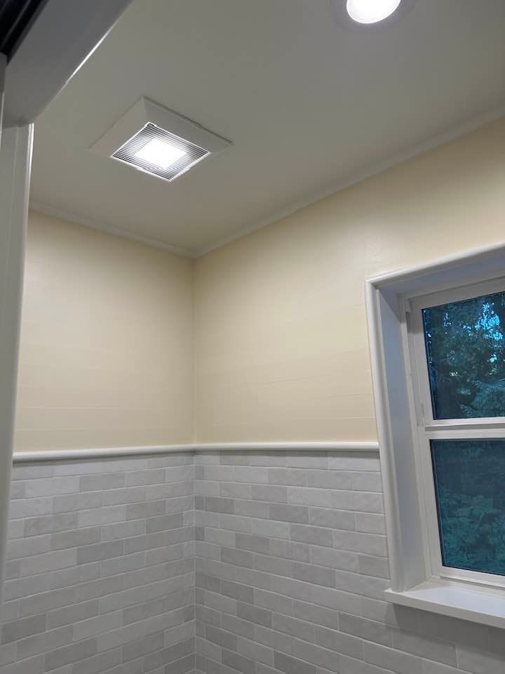 A bathroom with a window and a light on the ceiling.