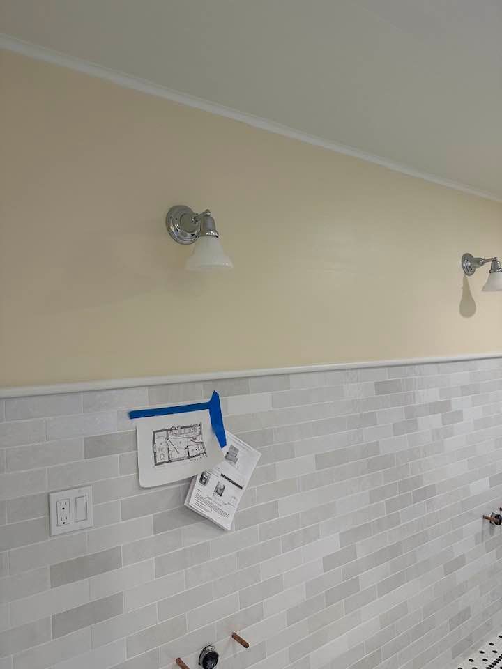 A kitchen with a brick wall and a lamp on the wall.