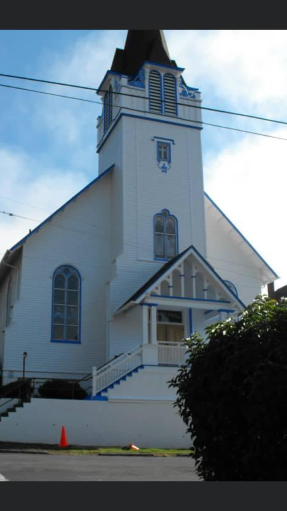 A white church with blue trim and a clock tower