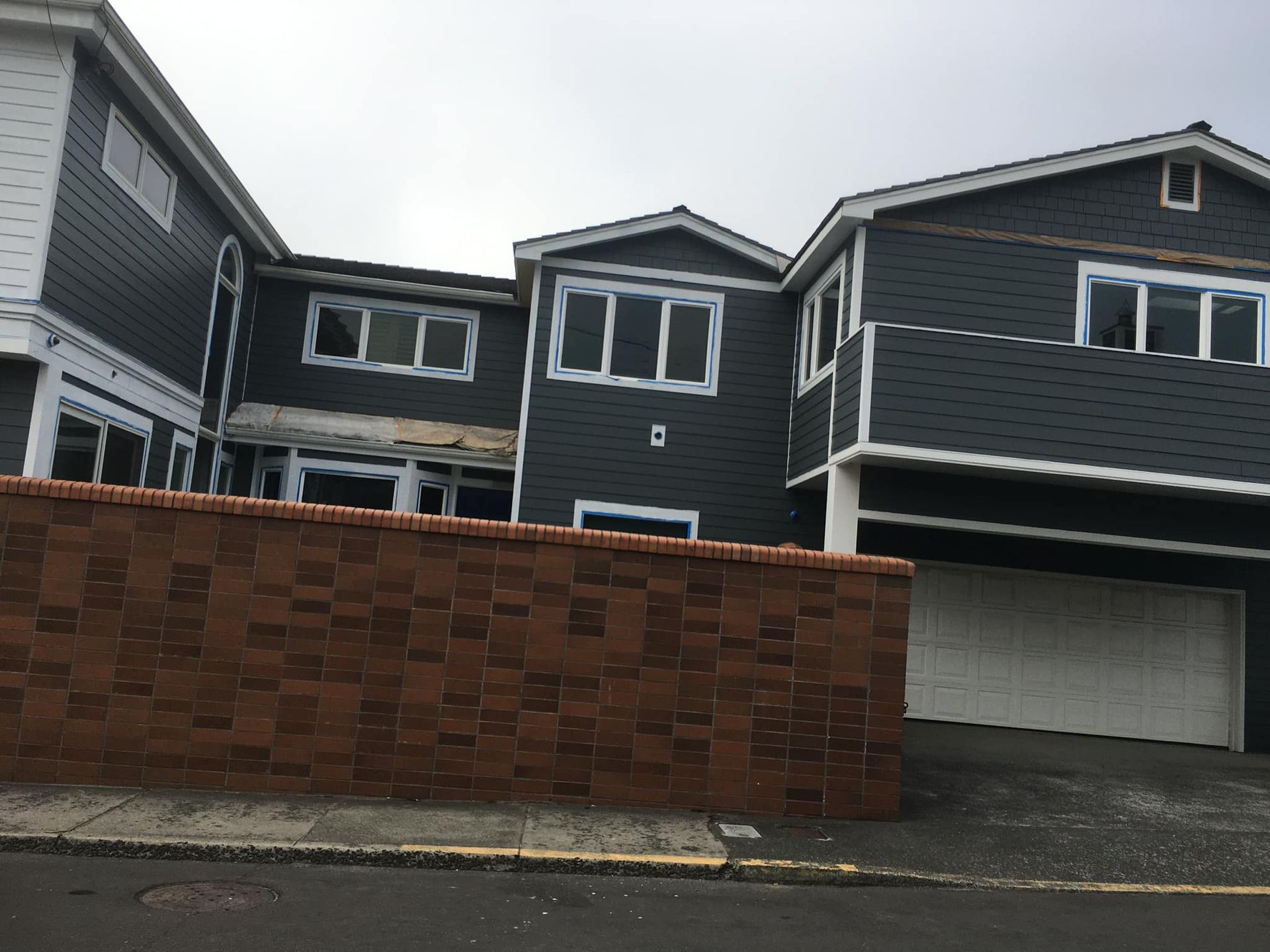 A large house with a brick wall in front of it
