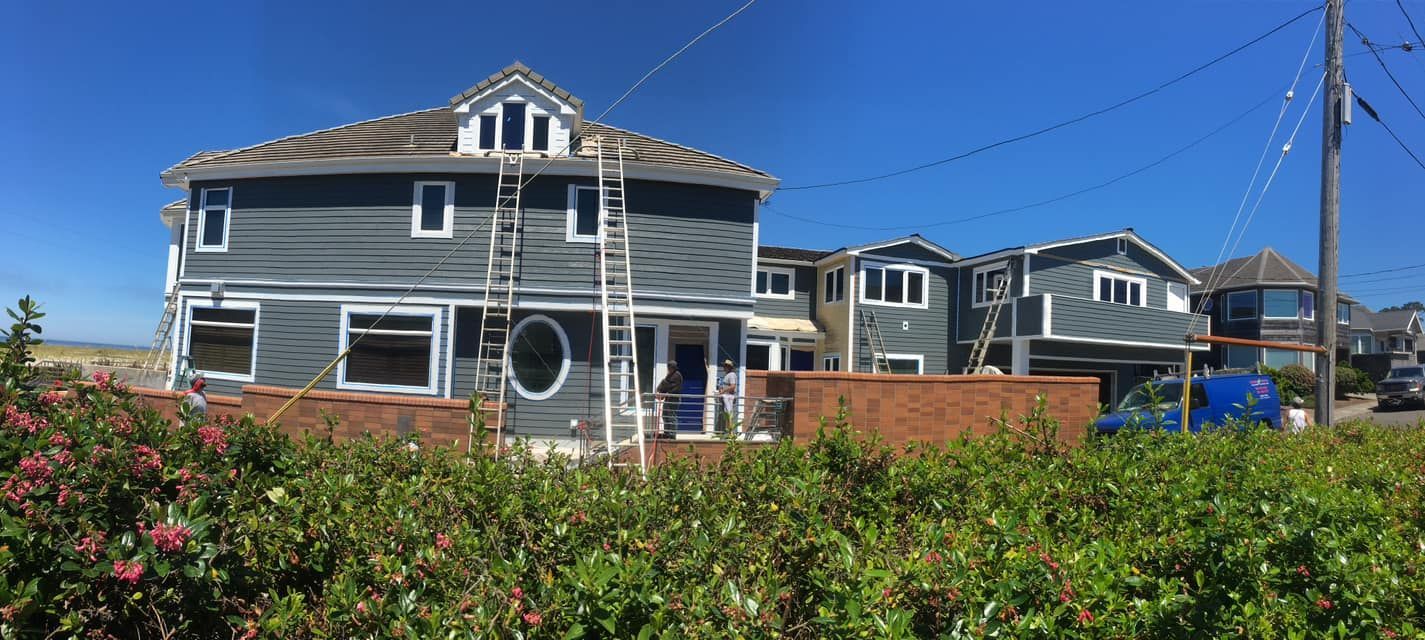 A large house is sitting in the middle of a lush green field.