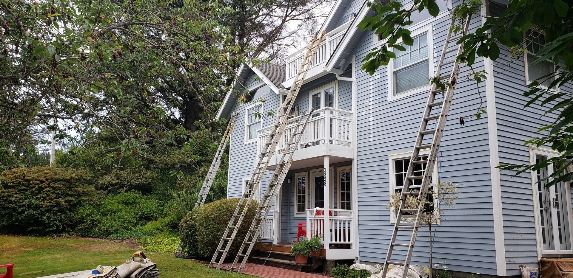 A house is being painted with a ladder attached to it.
