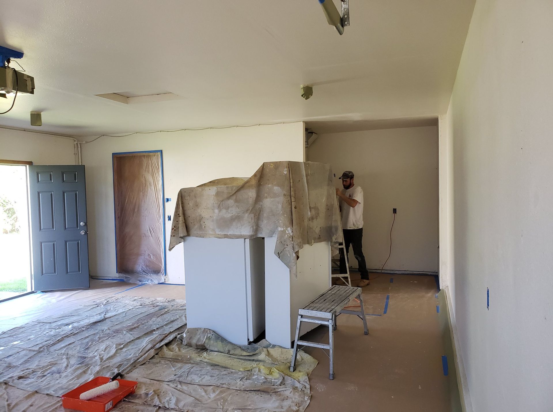 A man is painting a wall in a room.