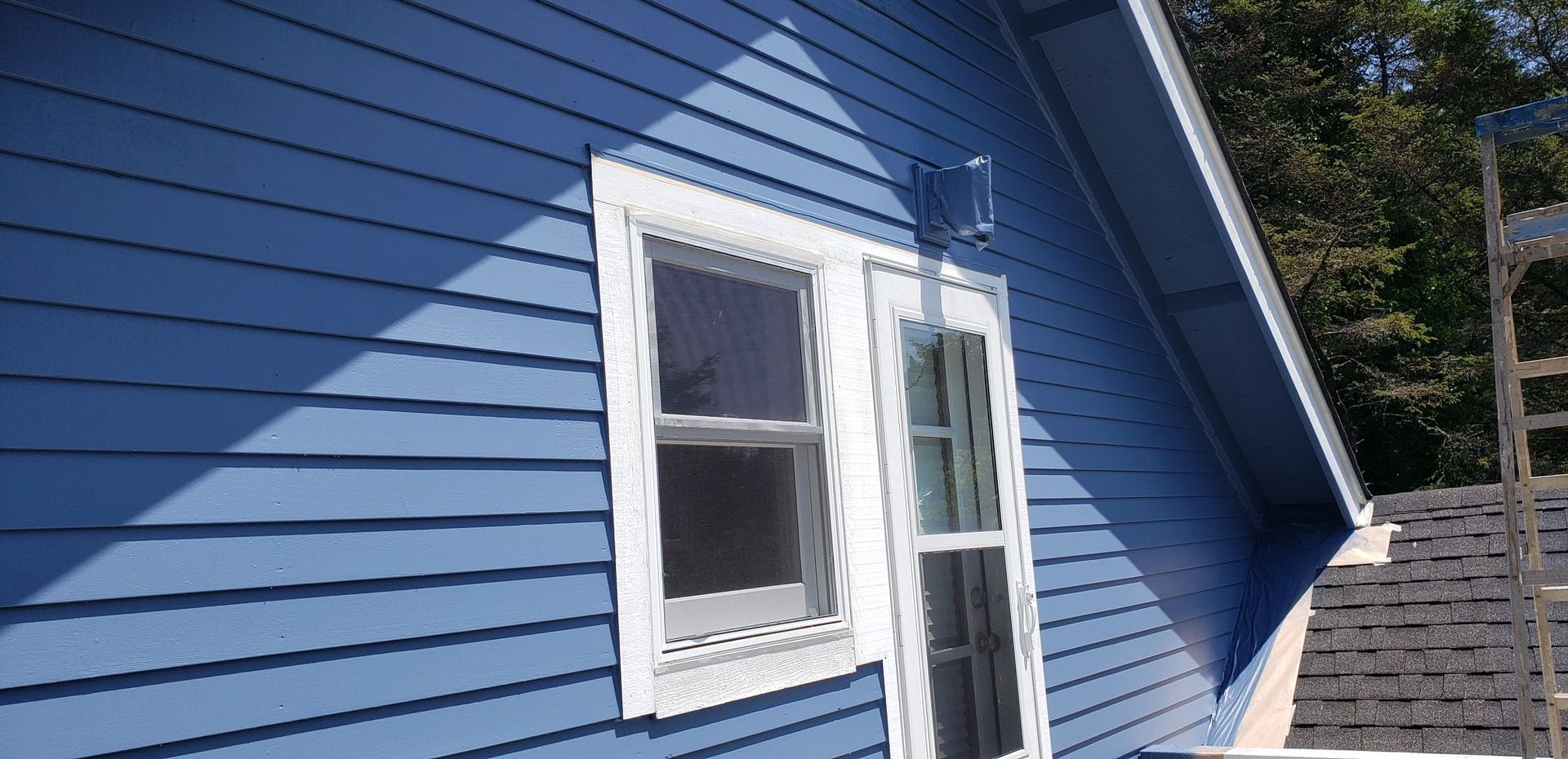 A blue house with a white window on the side
