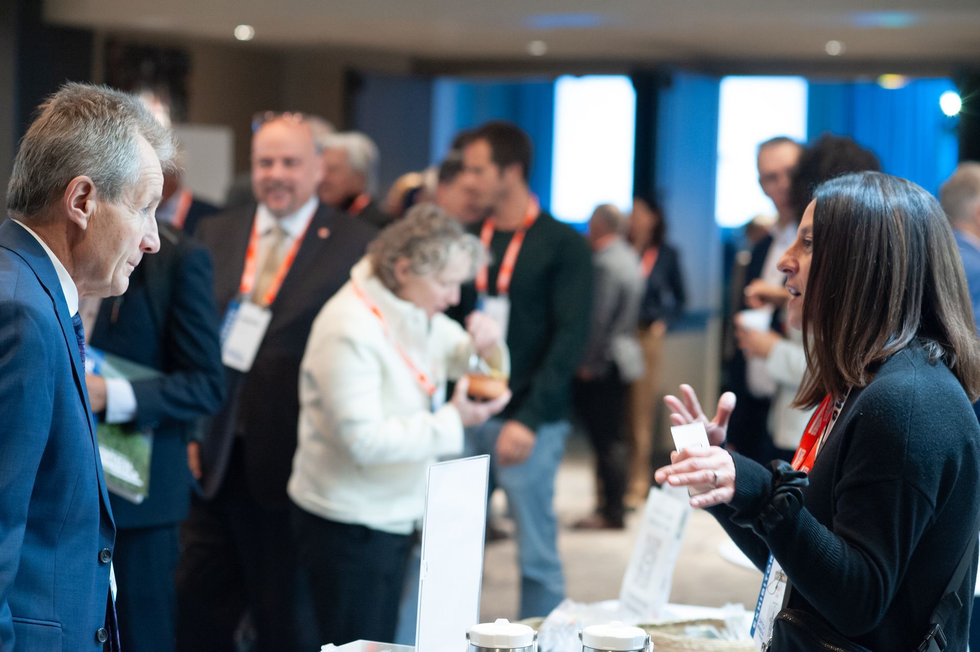 People in business attire talking and networking at a conference.
