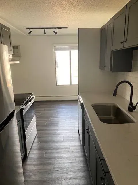 Kitchen with gray cabinets, stainless steel appliances, and a window at Eagle Point Apartments in West St. Paul, MN.