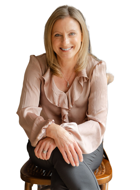 Picture of lady with blonde hair, smiling, sitting in a relaxed pose and wearing a cream blouse