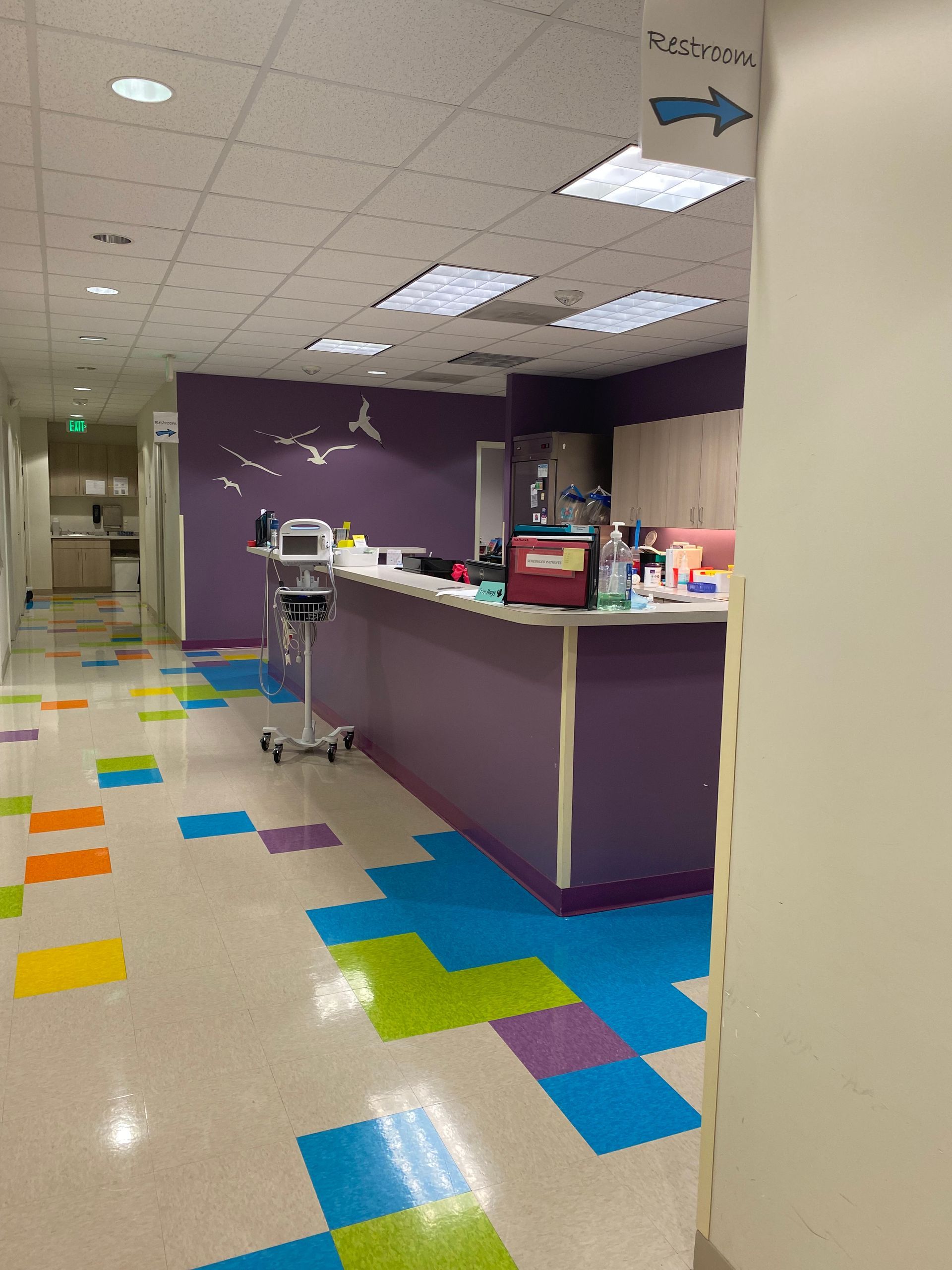 A hallway with colorful tiles and a purple counter at Dundalk Pediatric Associates