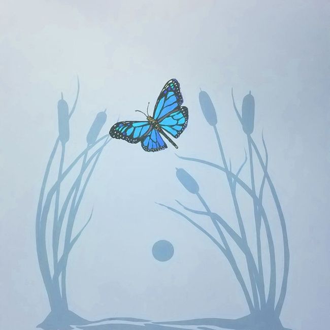 A blue butterfly is flying through a field of tall grass - mural at Dundalk Pediatric Associates