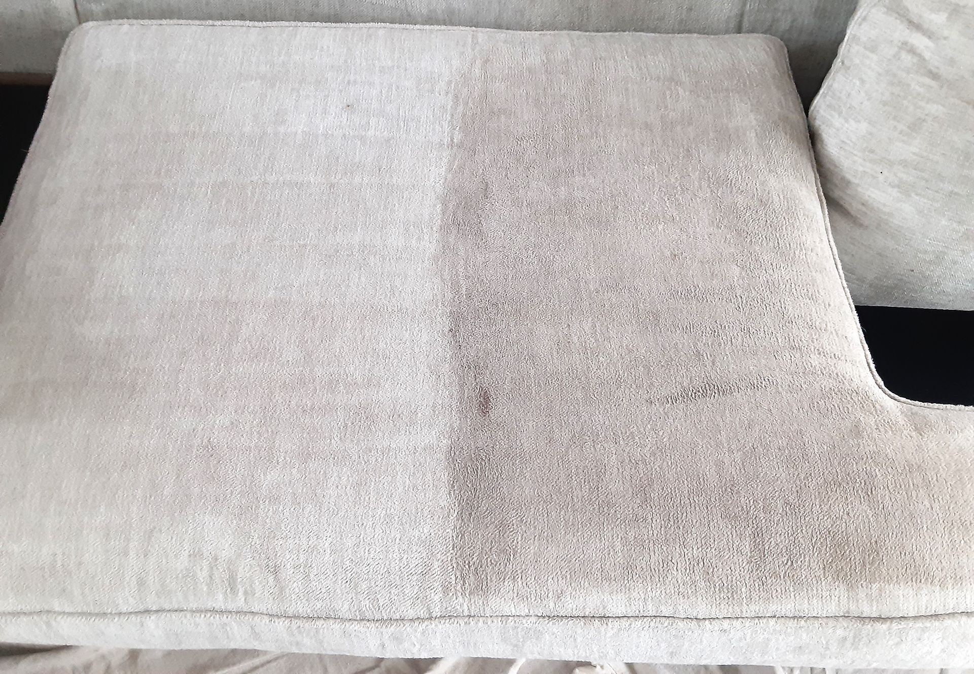 Couch cushion cleaned on one half. The left half is light tan, the right half is darker, showing the dirt.