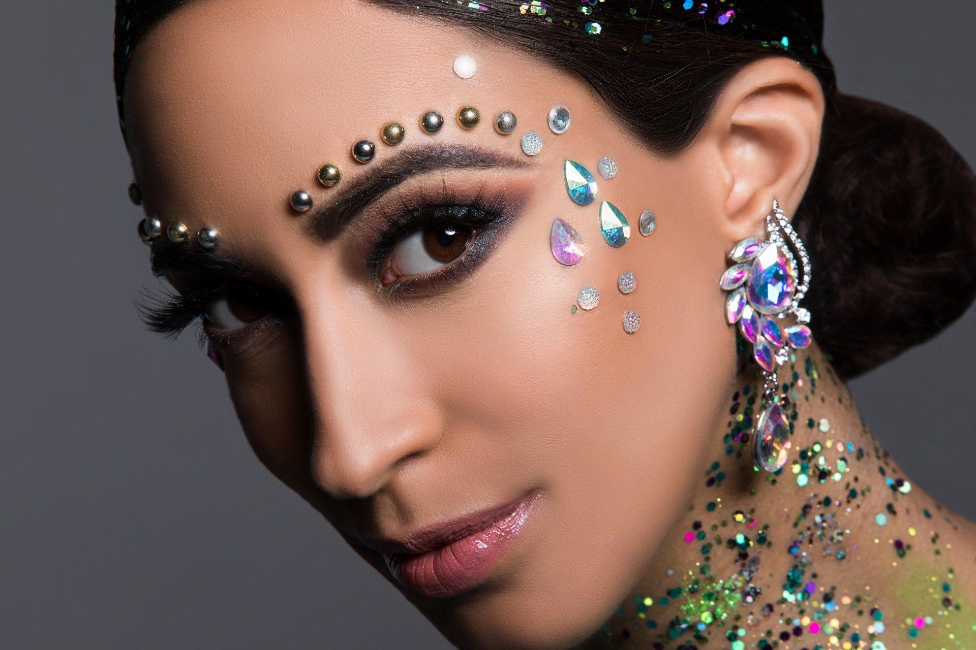 A close up of a woman 's face with rhinestones and glitter on it.