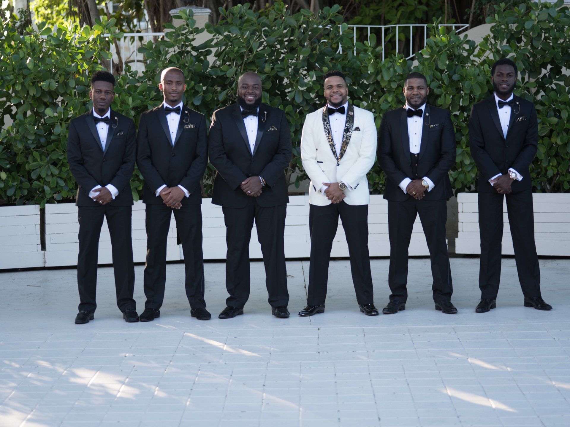 A group of men in tuxedos standing next to each other