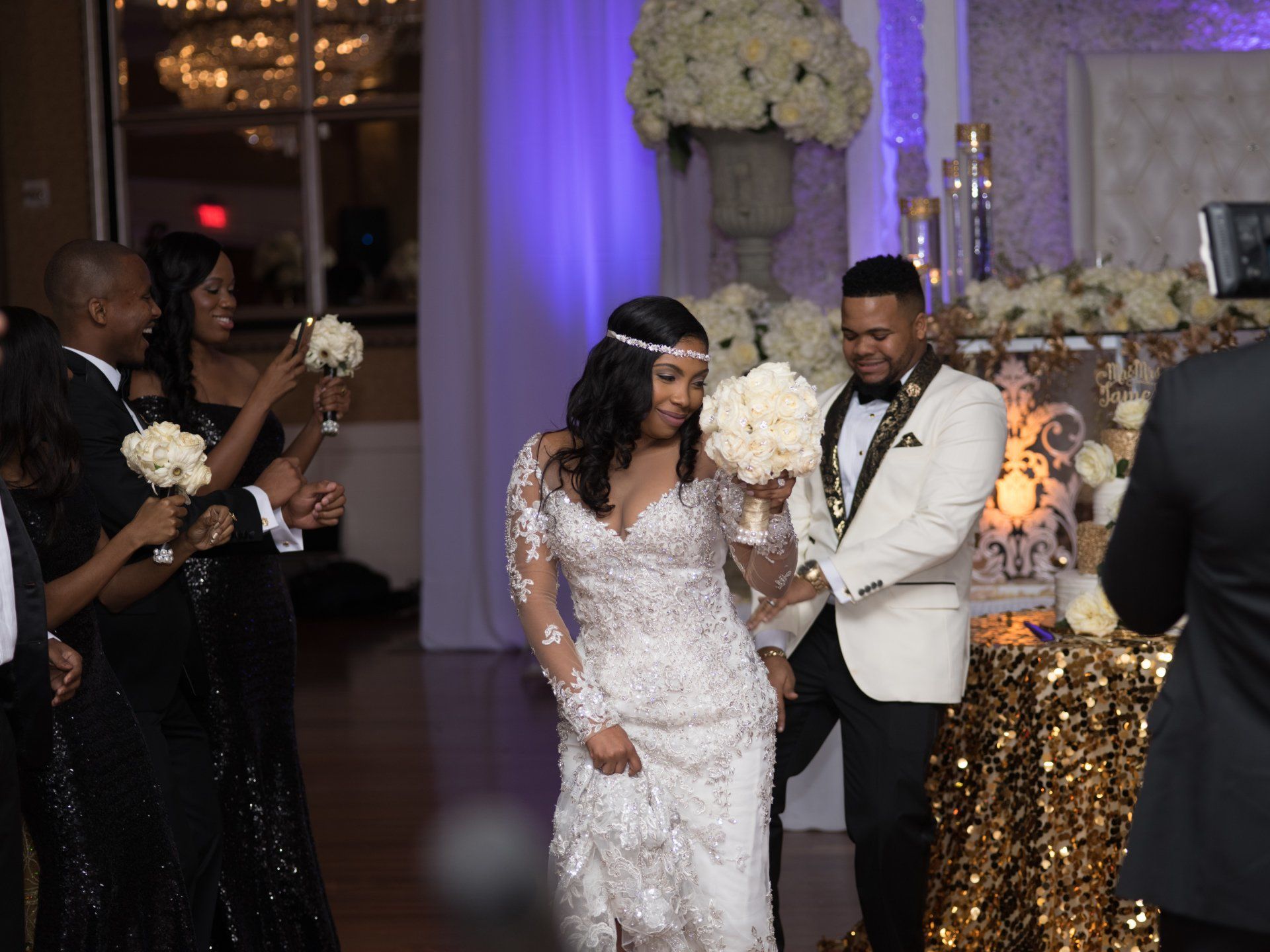 A bride and groom are walking down the aisle at their wedding reception.