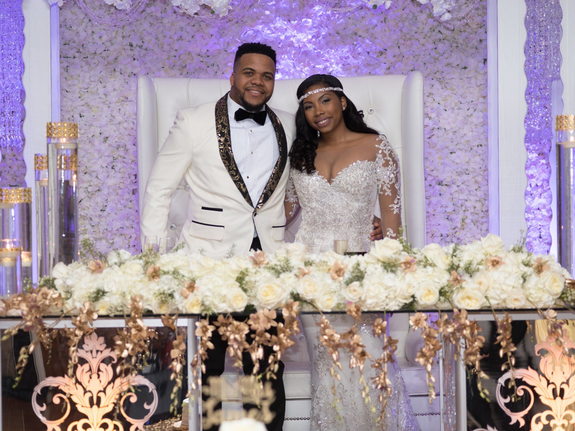 A bride and groom are posing for a picture at their wedding reception.
