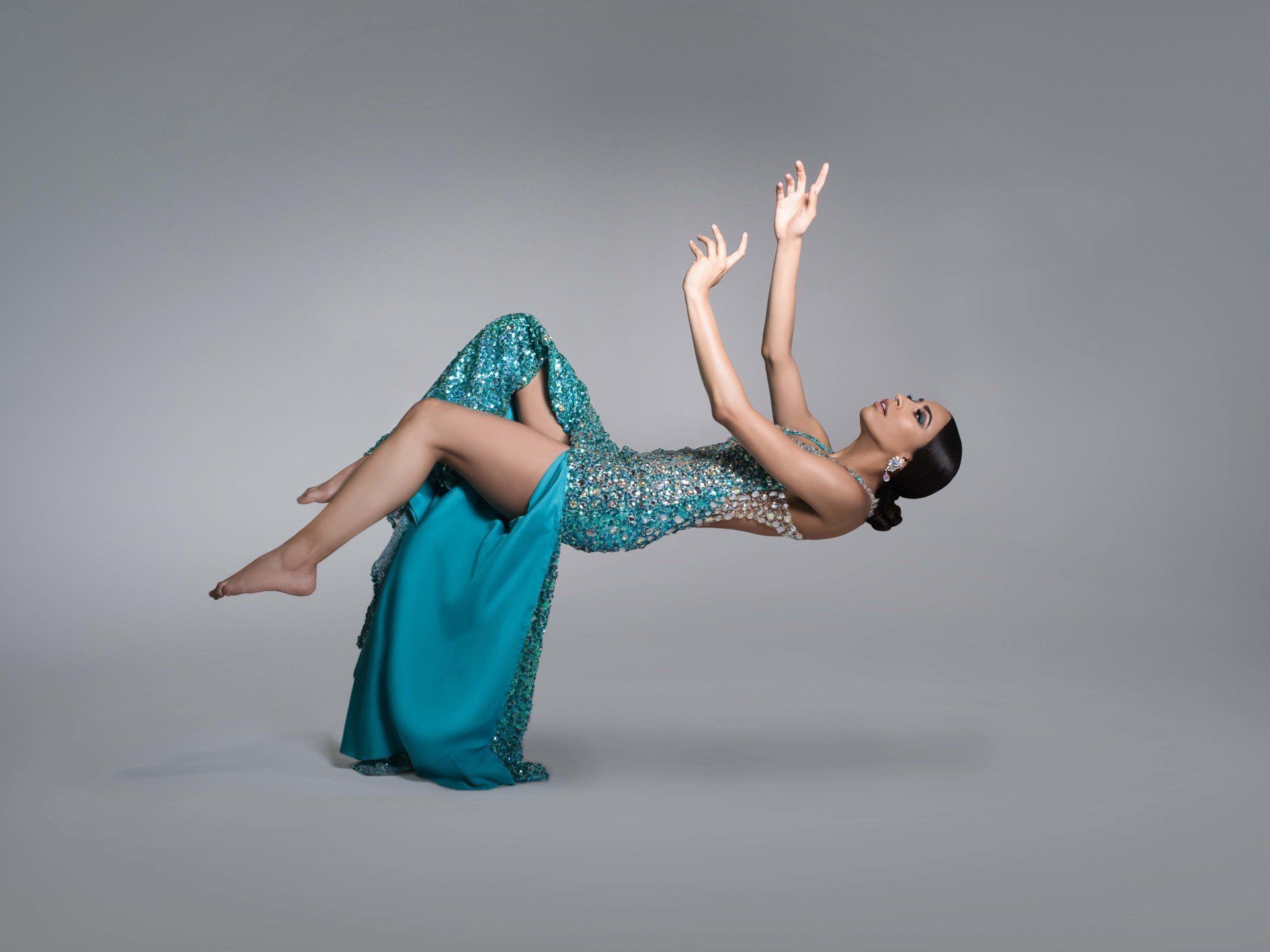 A woman in a blue dress is floating in the air.