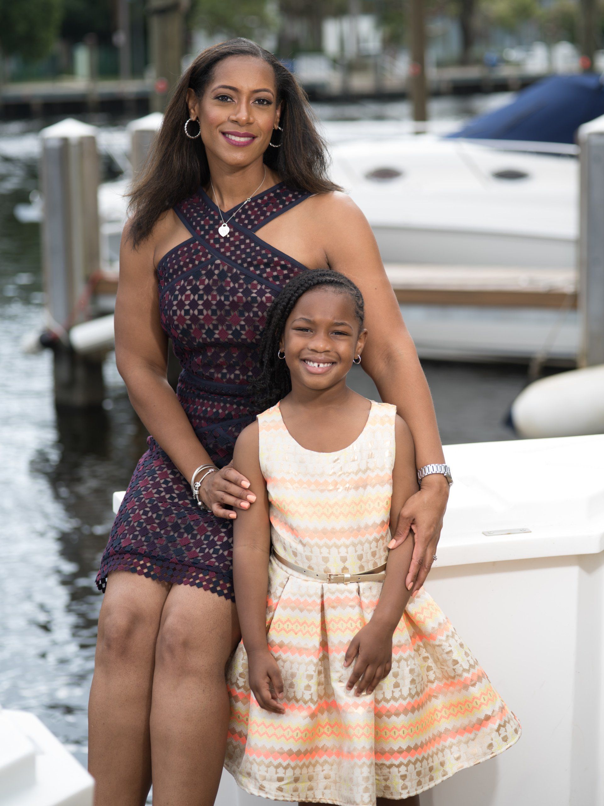 A woman and a little girl are posing for a picture on a boat.