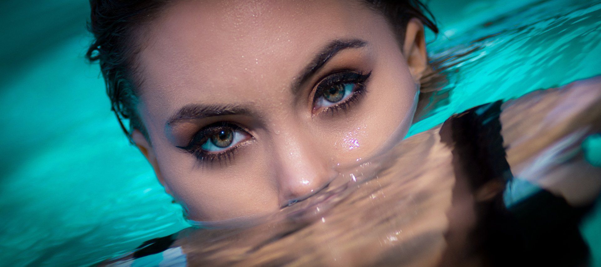 A woman is swimming in a pool with her face in the water.