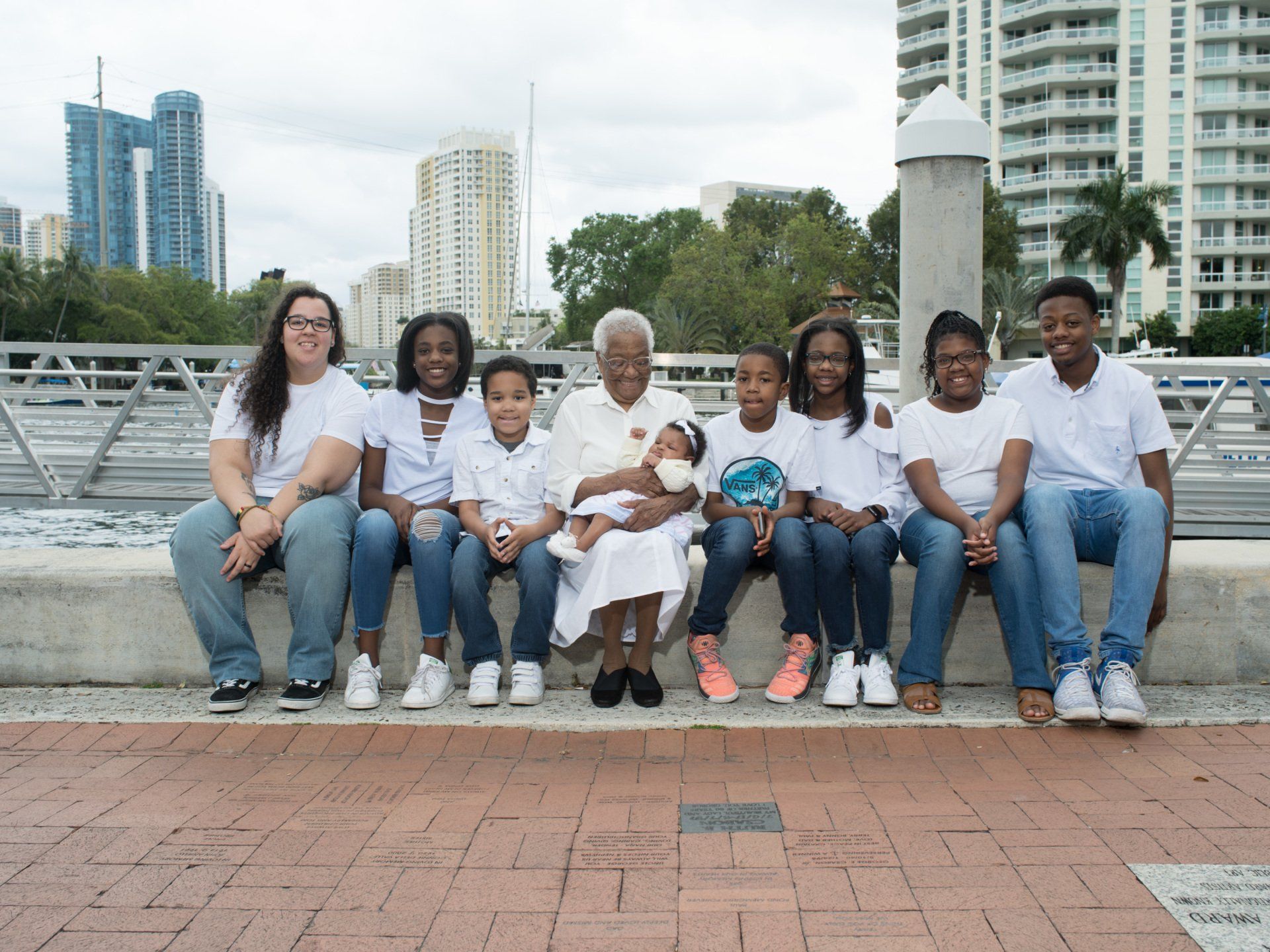 A group of people are sitting on a brick wall.
