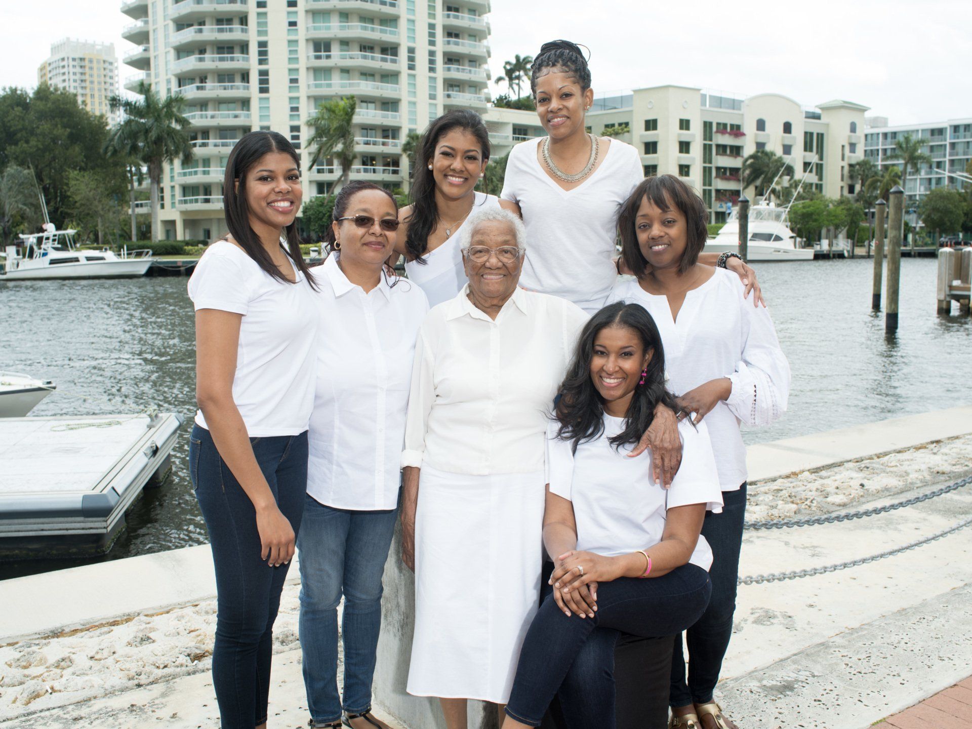 A group of women are posing for a picture in front of a body of water.