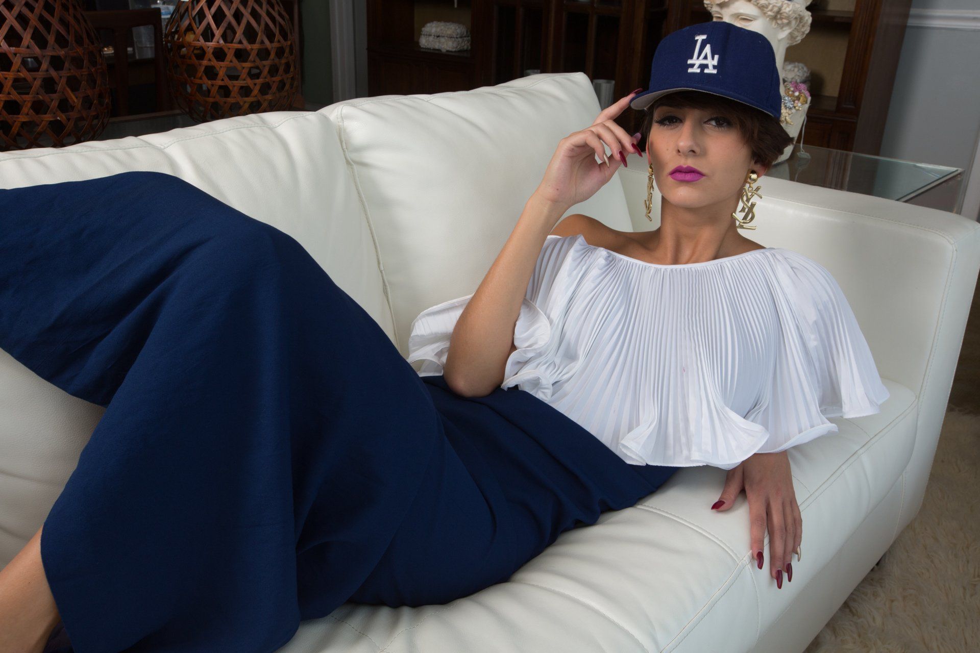 A woman wearing a la hat is laying on a couch
