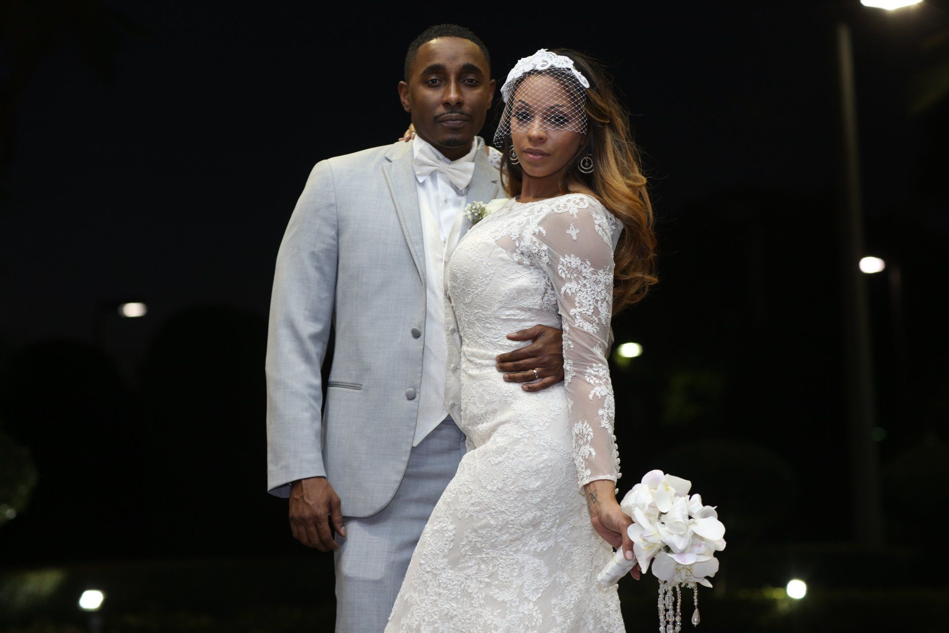 A bride and groom are posing for a picture at their wedding.