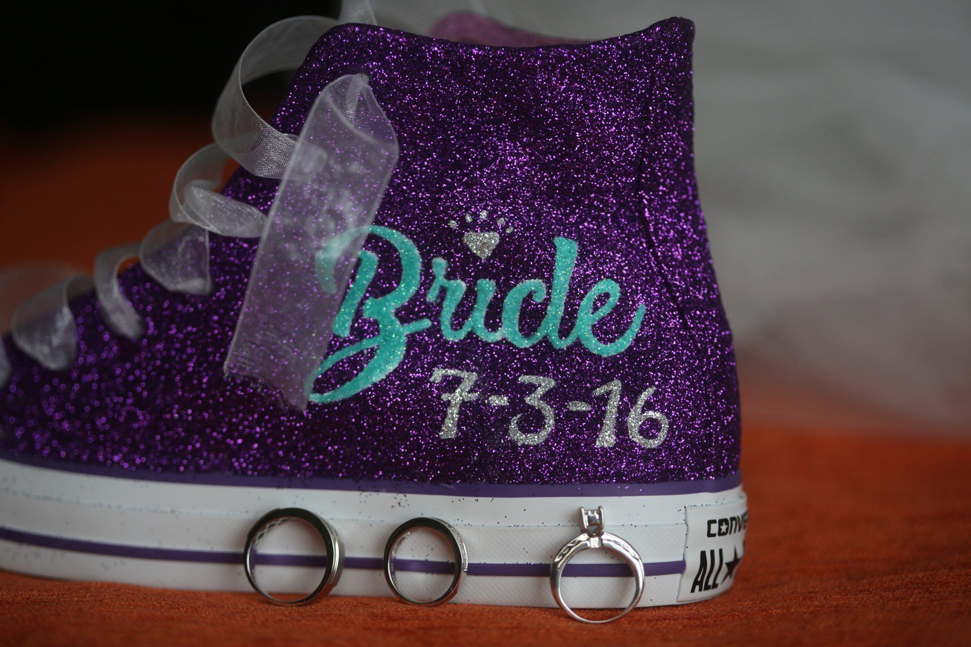 A purple converse shoe with the words bride written on it