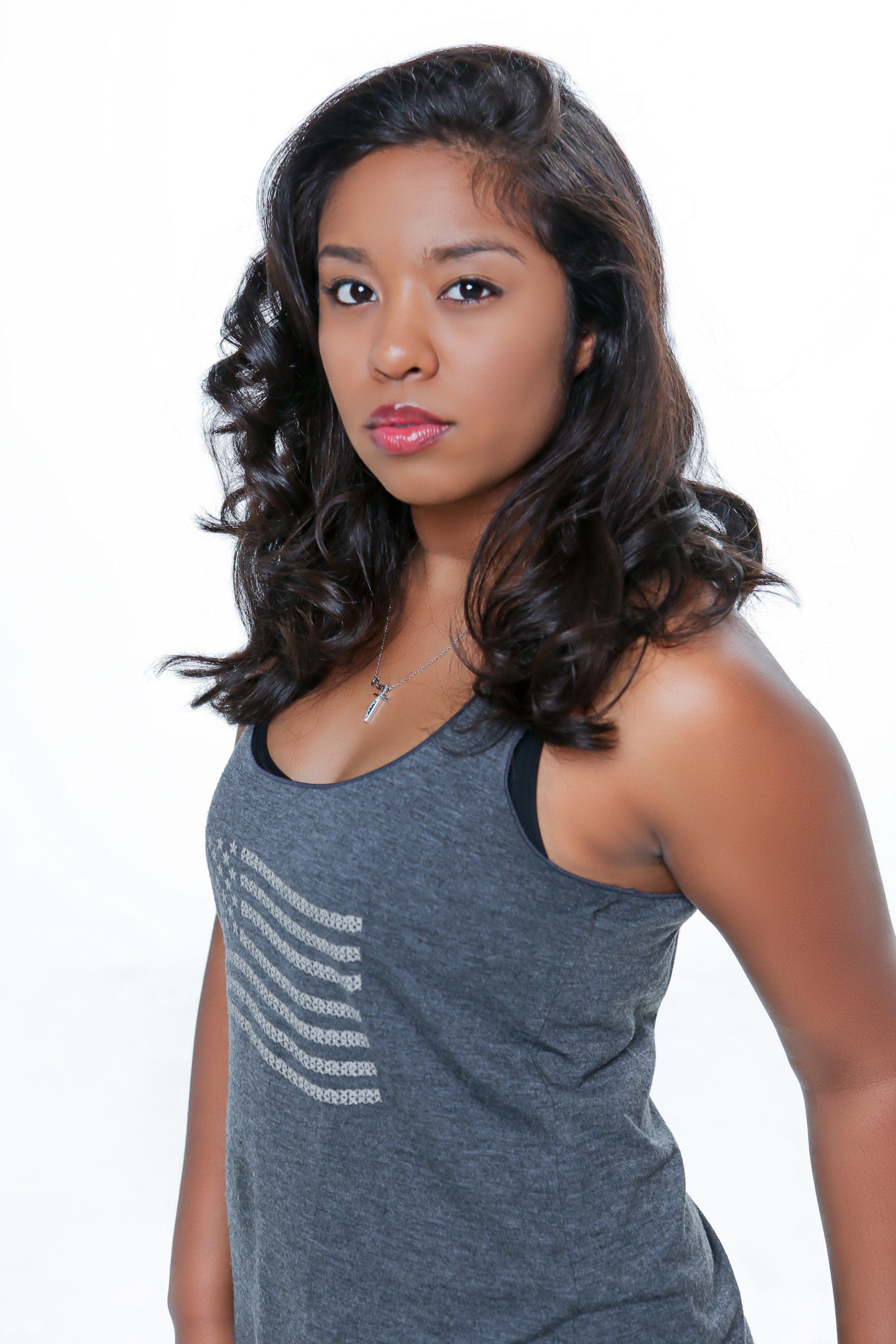 A woman is wearing a grey tank top with a pocket on the front