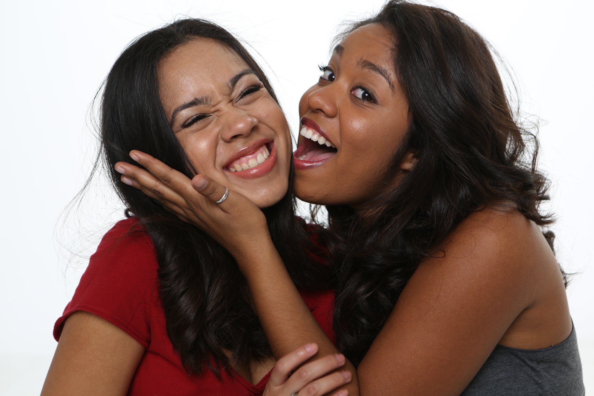 Two women are hugging each other and making funny faces