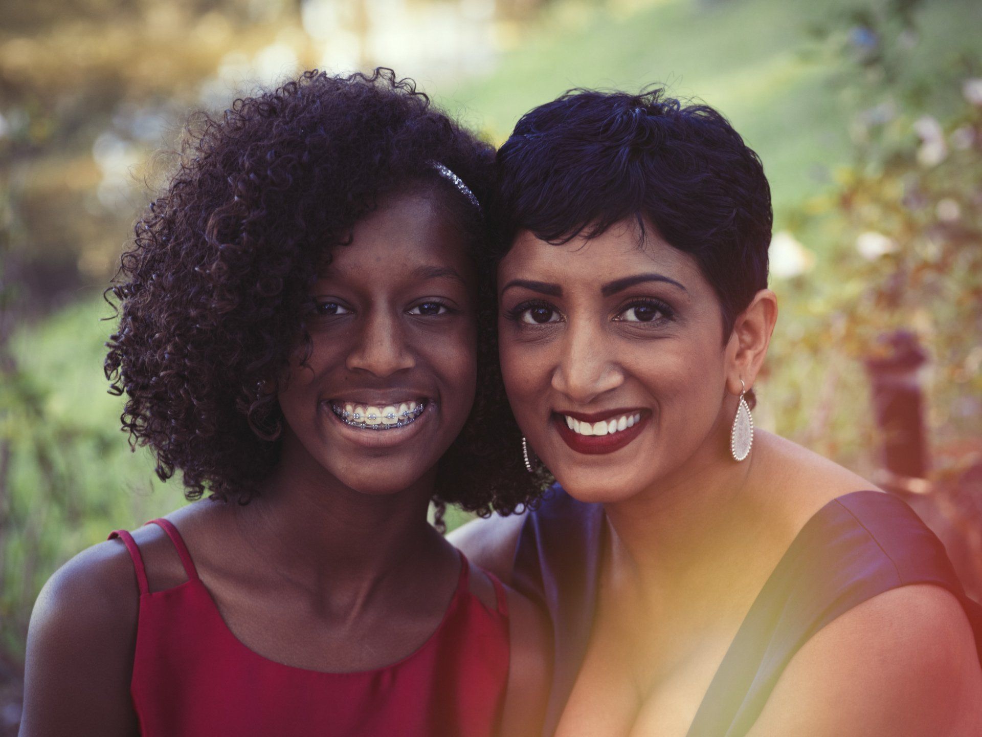 Two women are posing for a picture together and smiling for the camera.