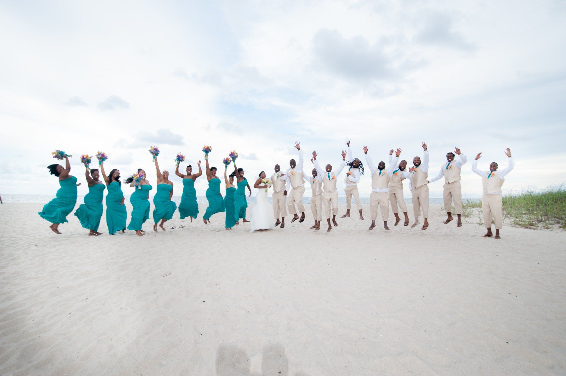 A large group of people are standing on a beach.