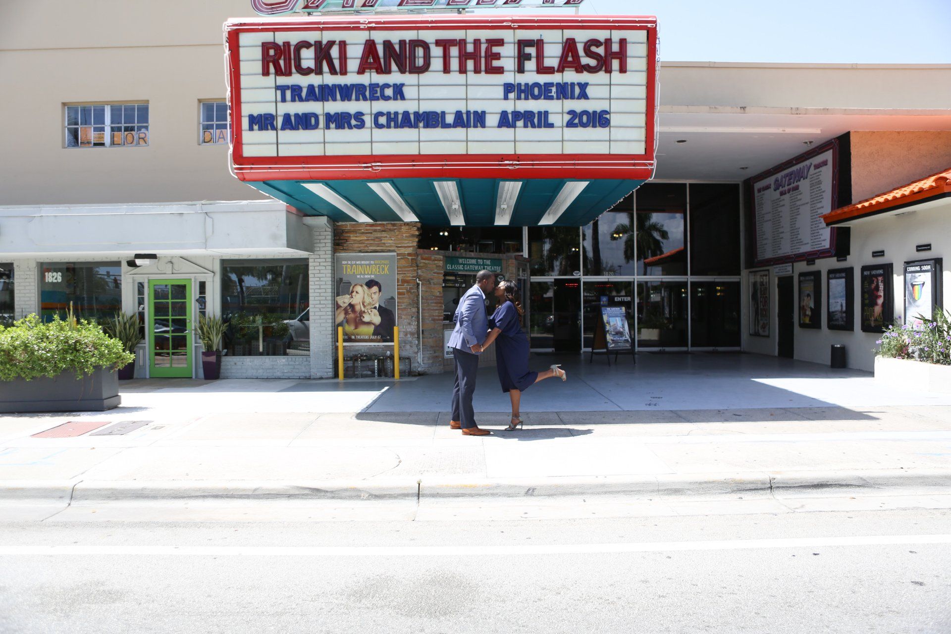 A couple standing in front of a rick and the flash theater