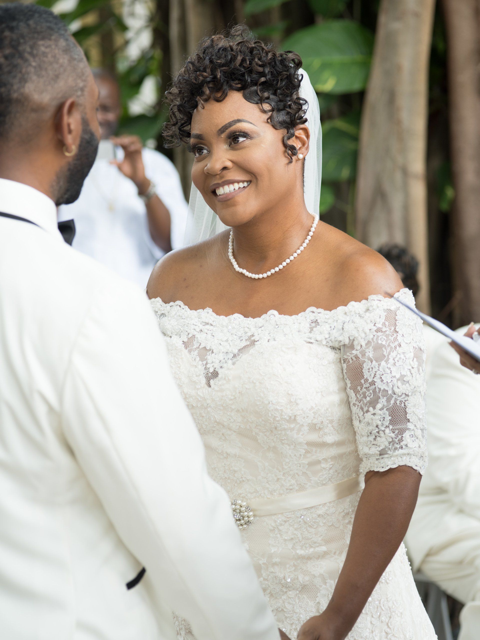 A bride and groom are holding hands during their wedding ceremony
