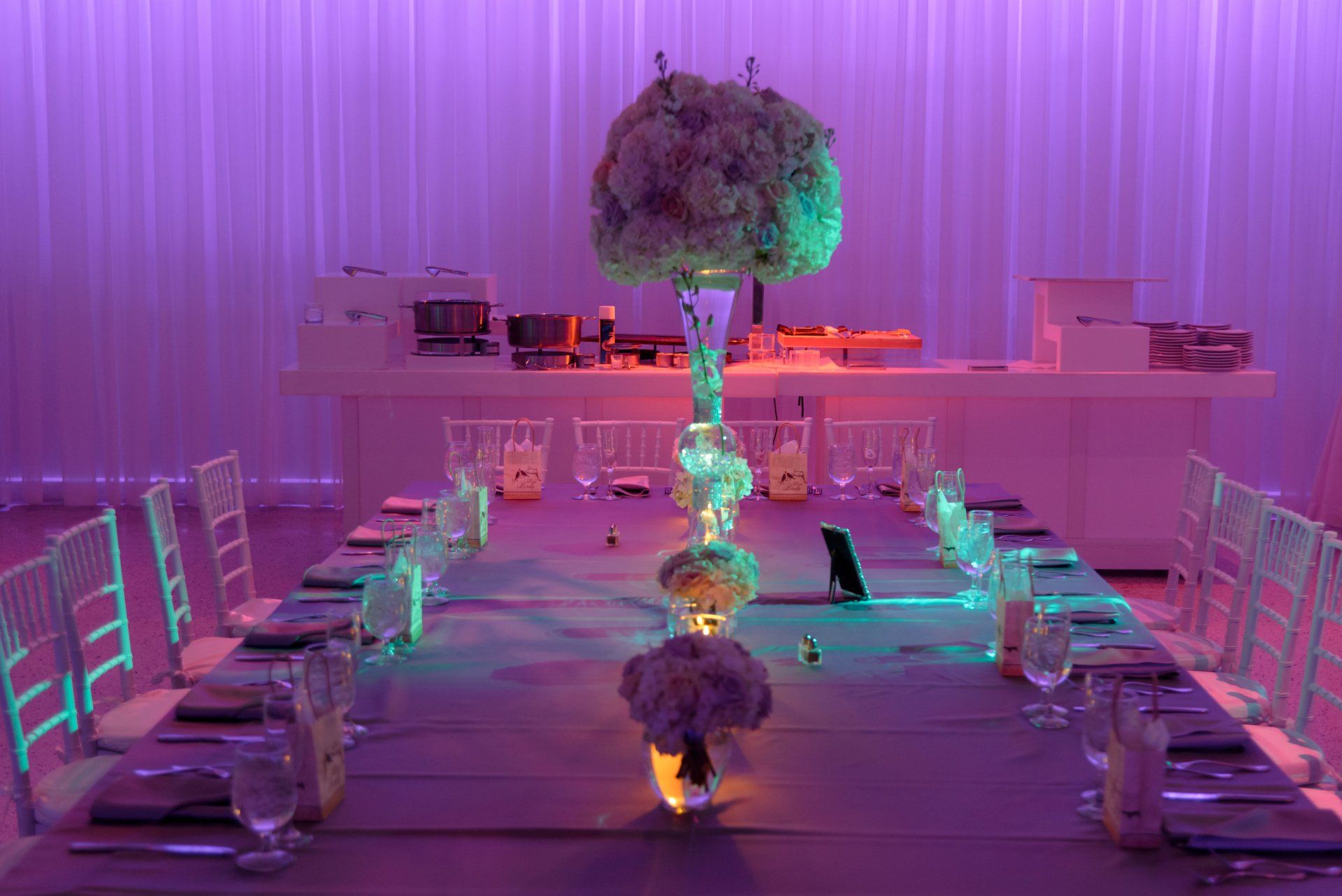 A long table with a vase of flowers on top of it.