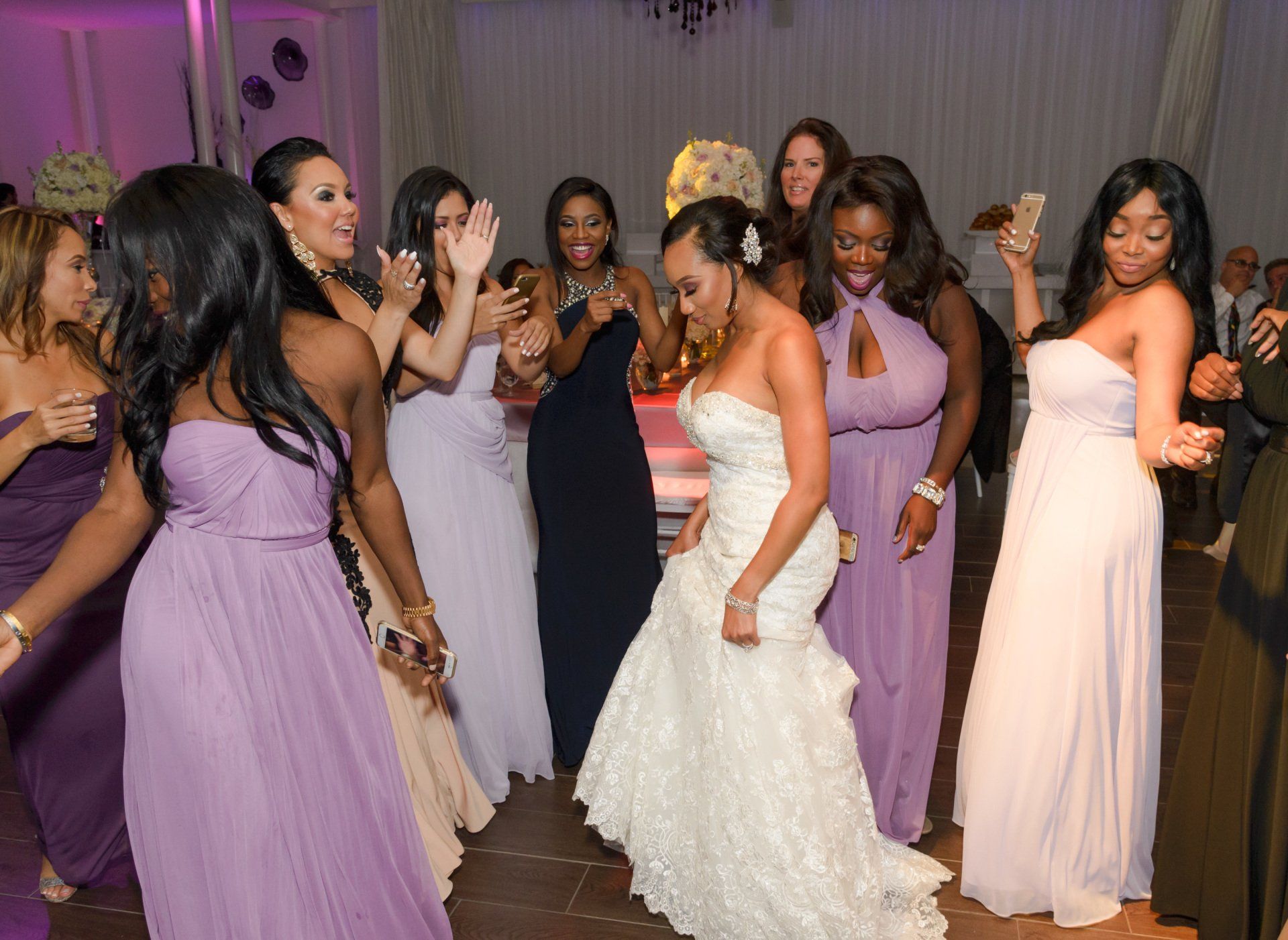 A bride and her bridesmaids are dancing at a wedding reception