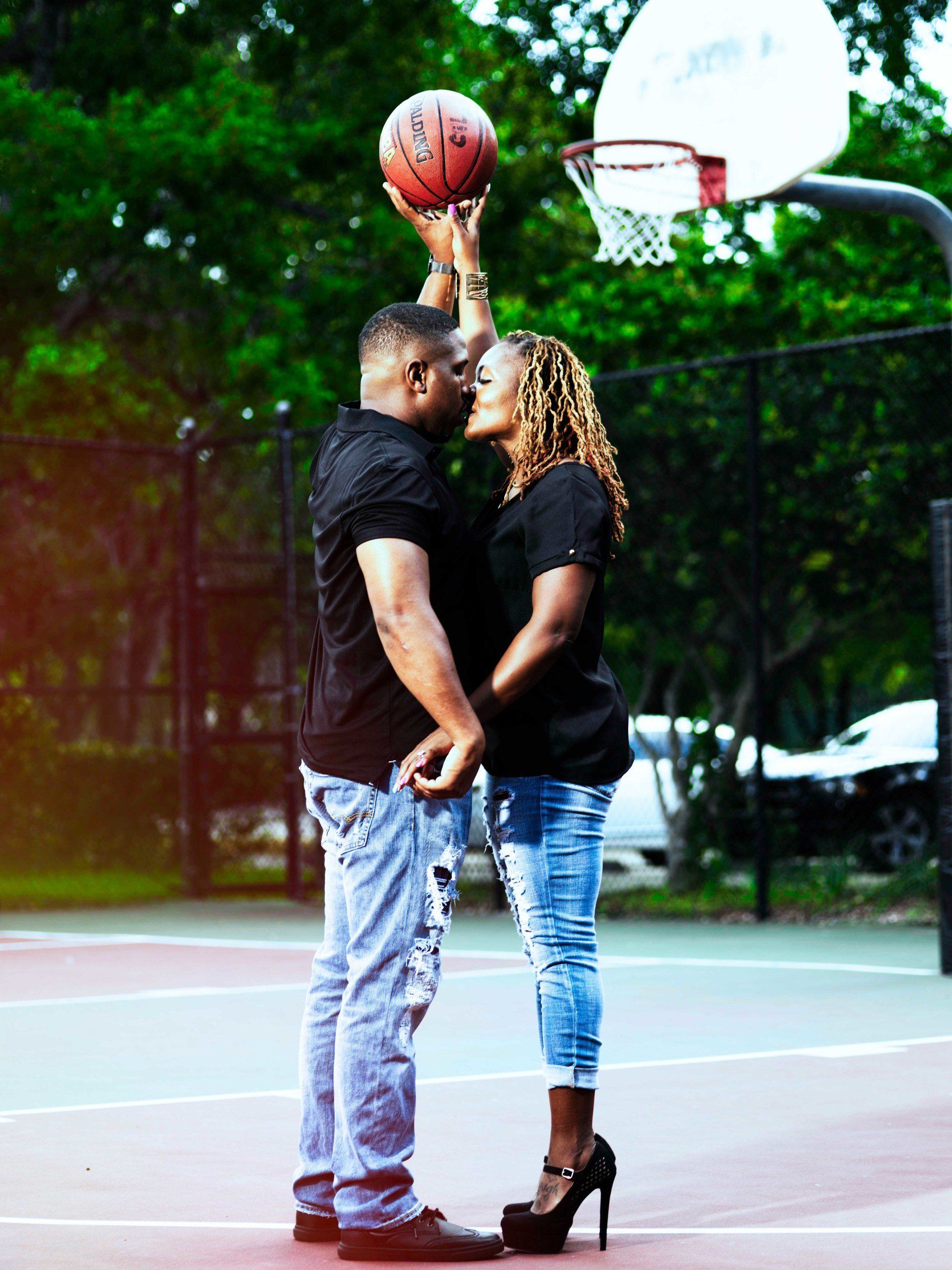 A man is holding a basketball over a woman 's head
