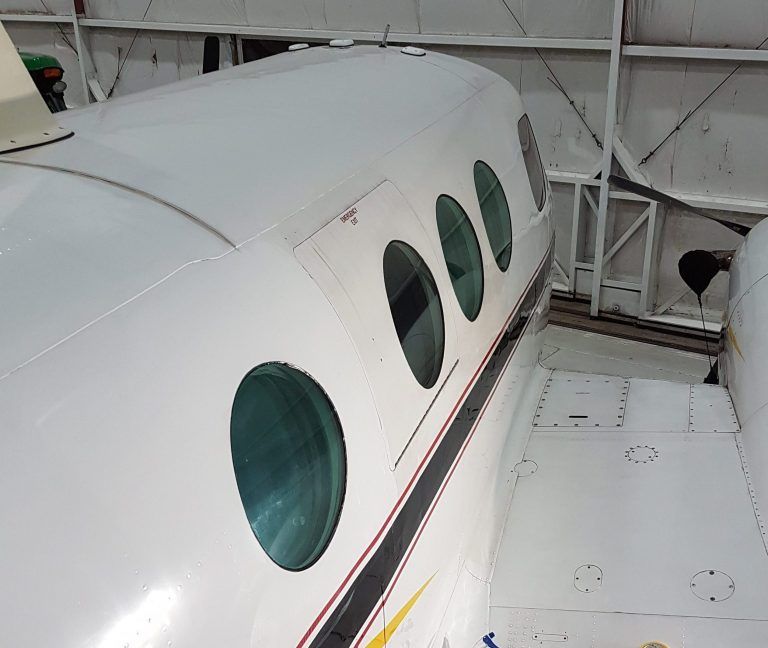 White airplane fuselage with round windows.