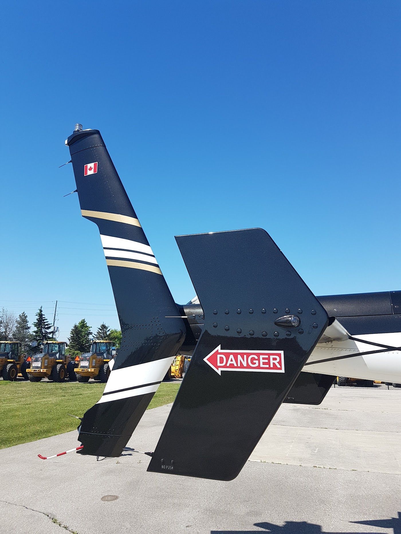 Black aircraft tail with gold stripes, red
