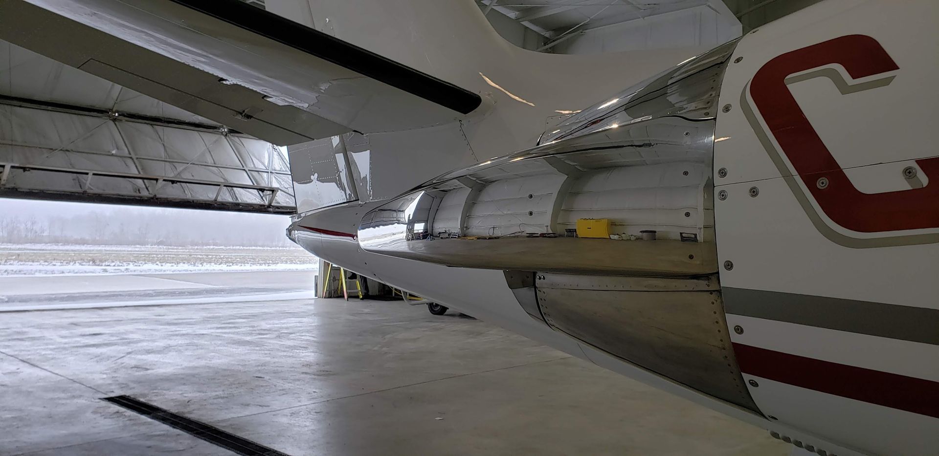 Underside view of a plane with its wing and engine visible. A large red