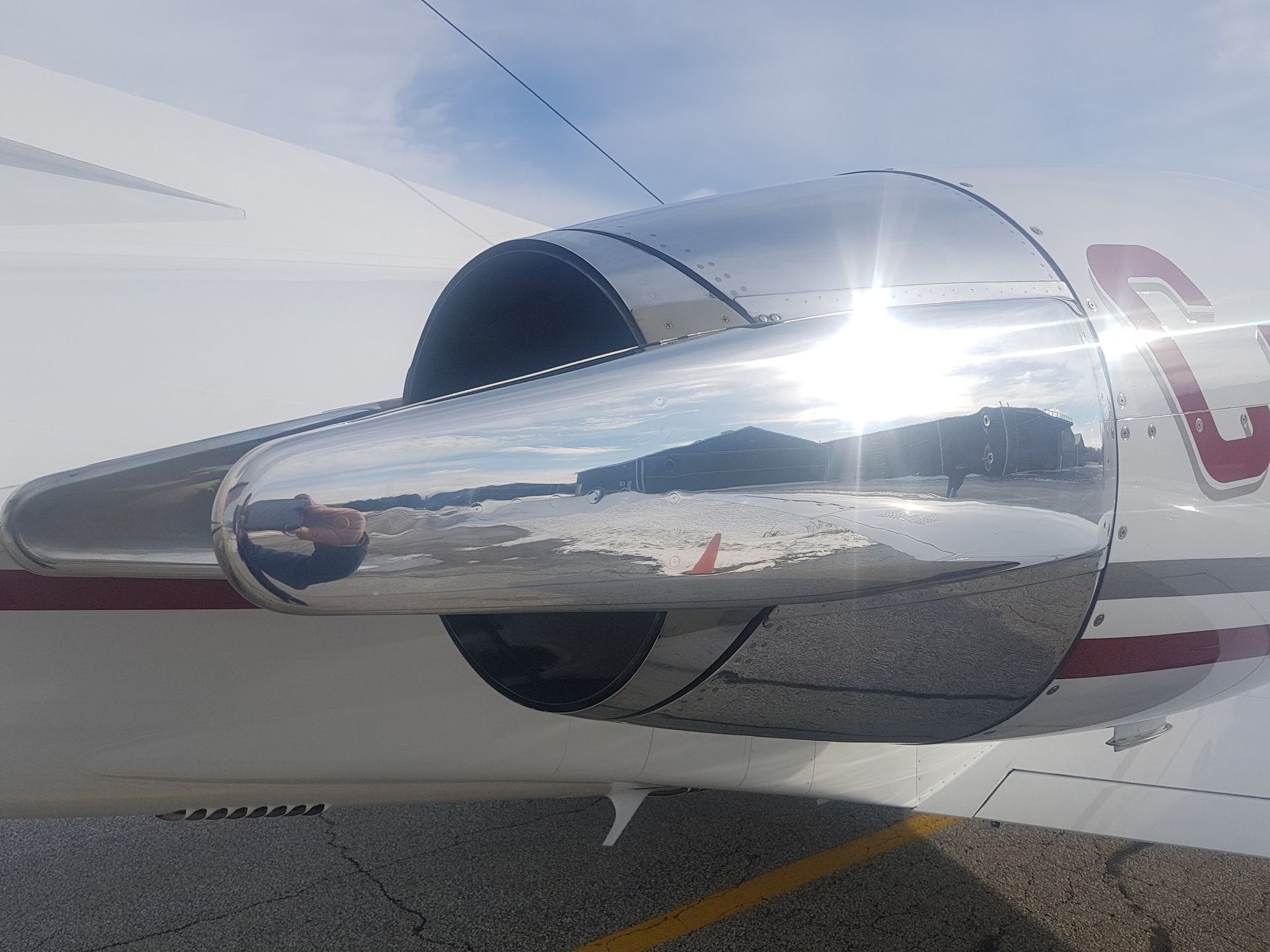 Chrome engine cowling of a private jet reflecting the environment.