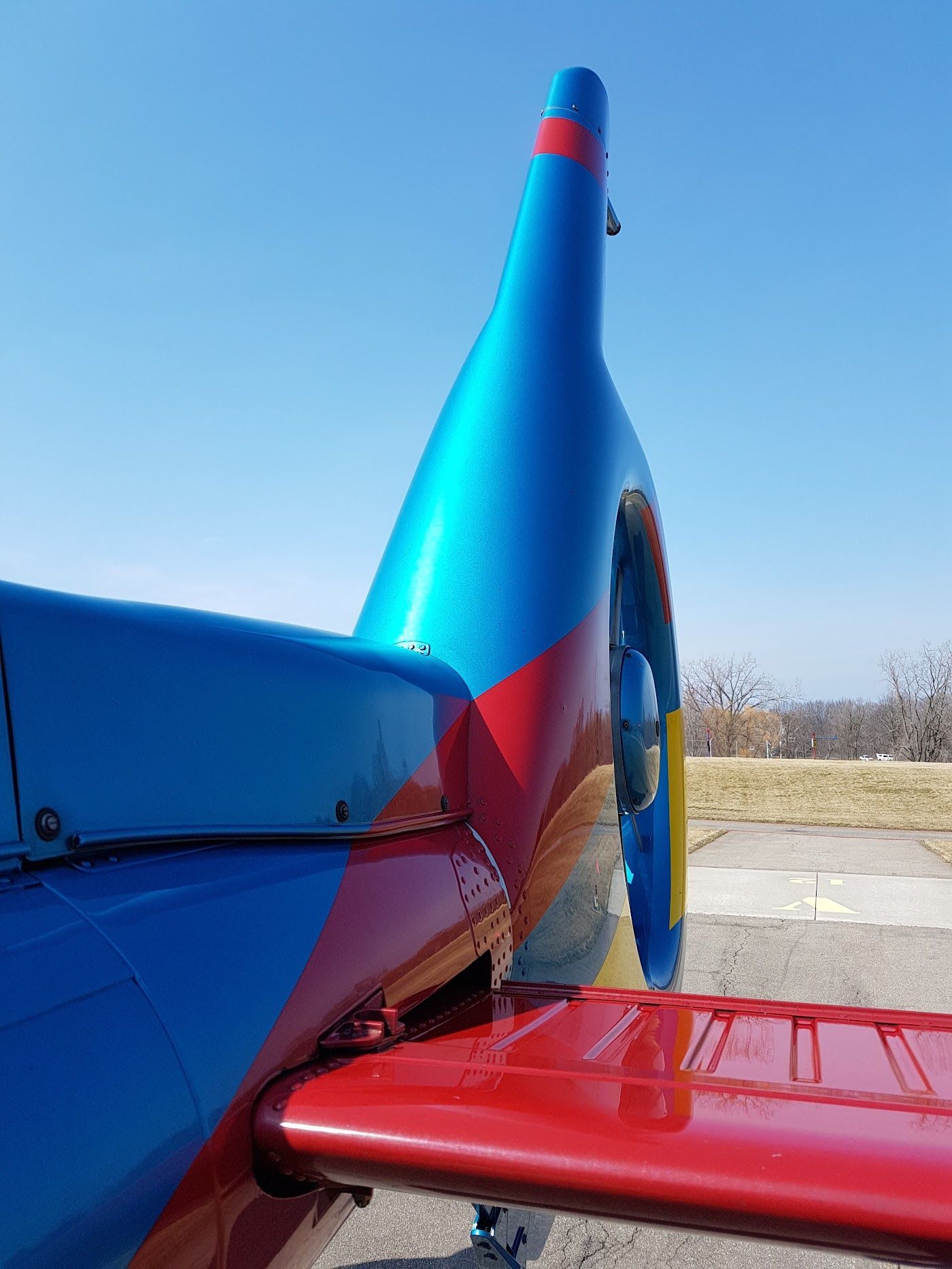 Blue and red airplane tail against a clear blue sky.