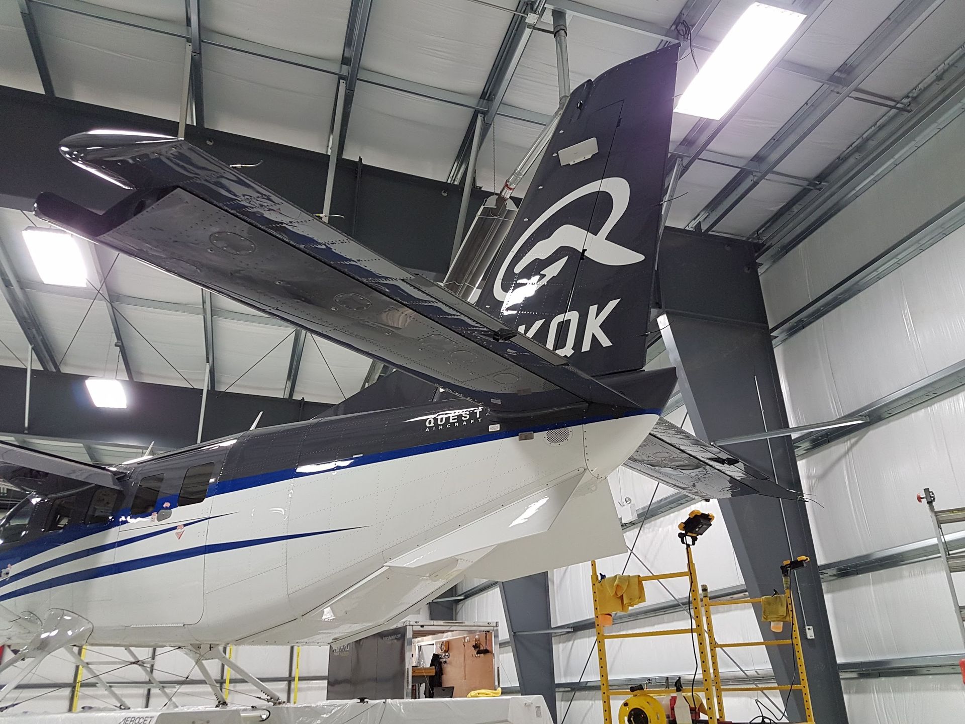 Black and white seaplane in a hangar; tail details including the letters